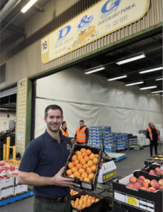 Man holding a tray of apricots